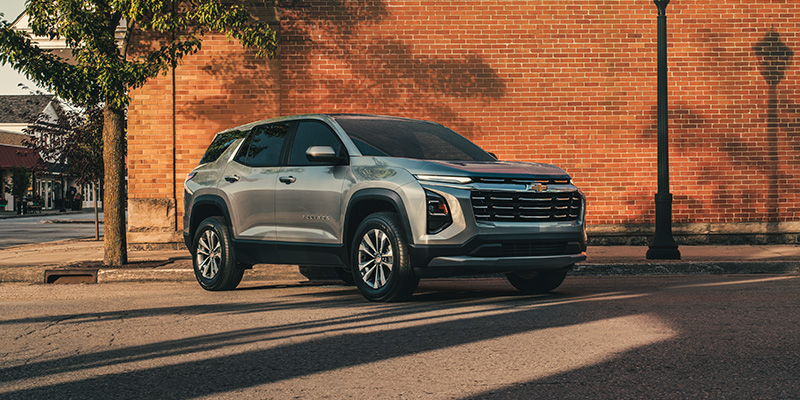 Chevrolet Equinox SUV parked on a city street near a brick building.