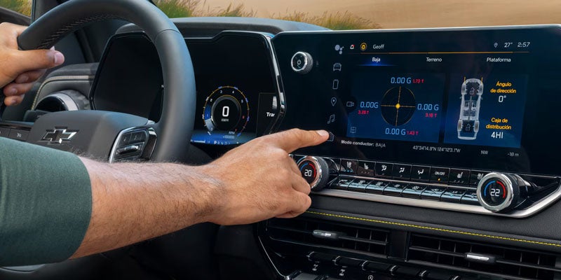 Close-up of the 2026 Chevrolet Colorado's touchscreen display, with a hand adjusting settings on the dashboard.