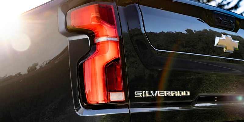 Close-up of Chevrolet Silverado taillight on black truck.