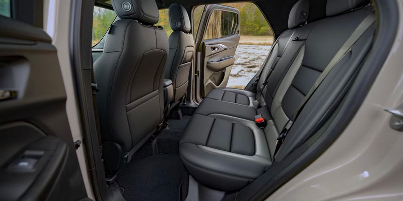 Rear passenger seats of Chevrolet Trailblazer SUV interior with door open.