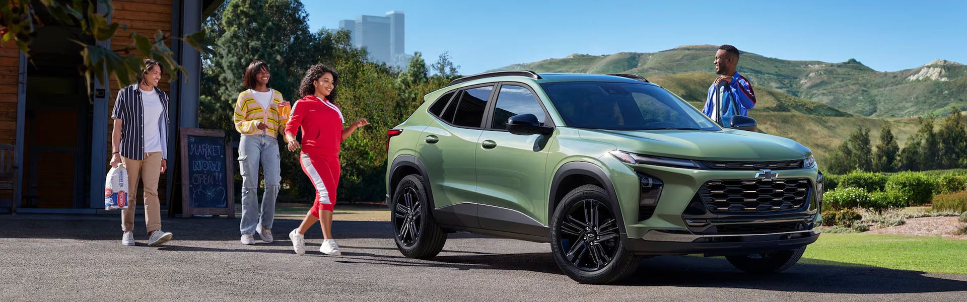 2026 Chevrolet Trax parked on a street with people walking nearby, showcasing its modern design.