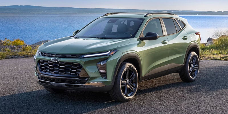 2026 Chevrolet Trax in green parked by a scenic waterfront, showcasing its sleek design.